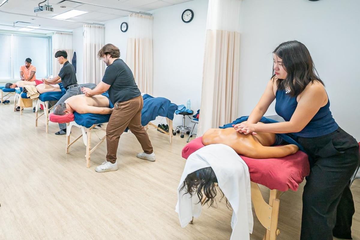 Massage therapy students practicing hands-on techniques in the CITCM classroom in Calgary.