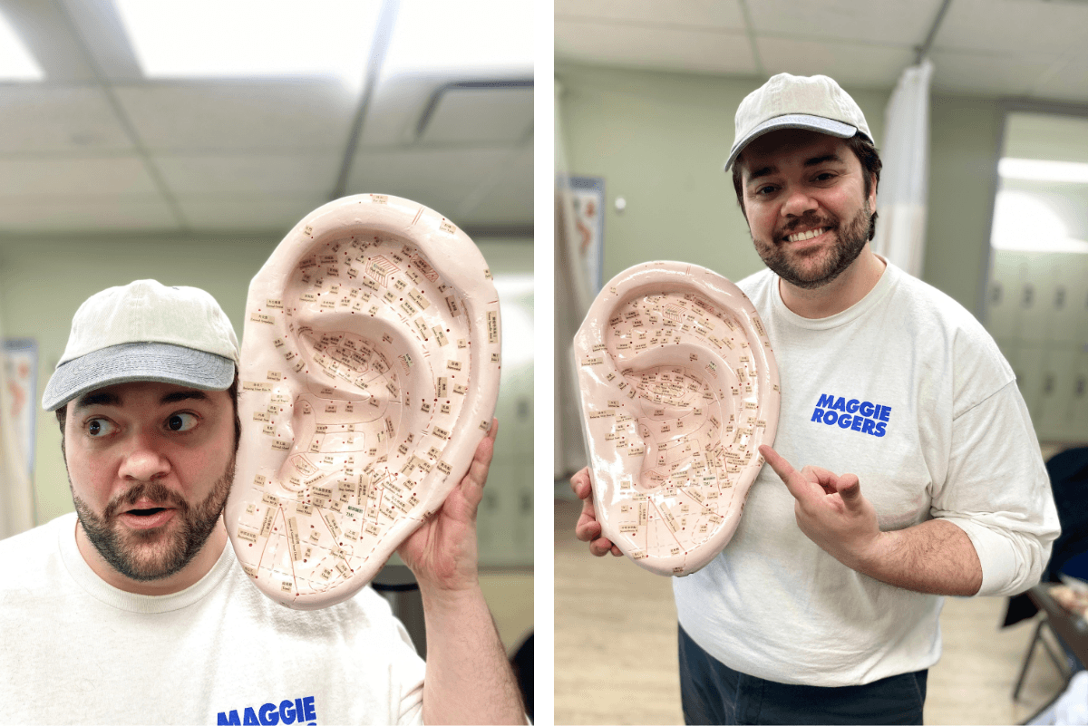 Justin Wilson, CITCM massage therapy student, holding an auricular acupuncture model used in Eastern medicine training.